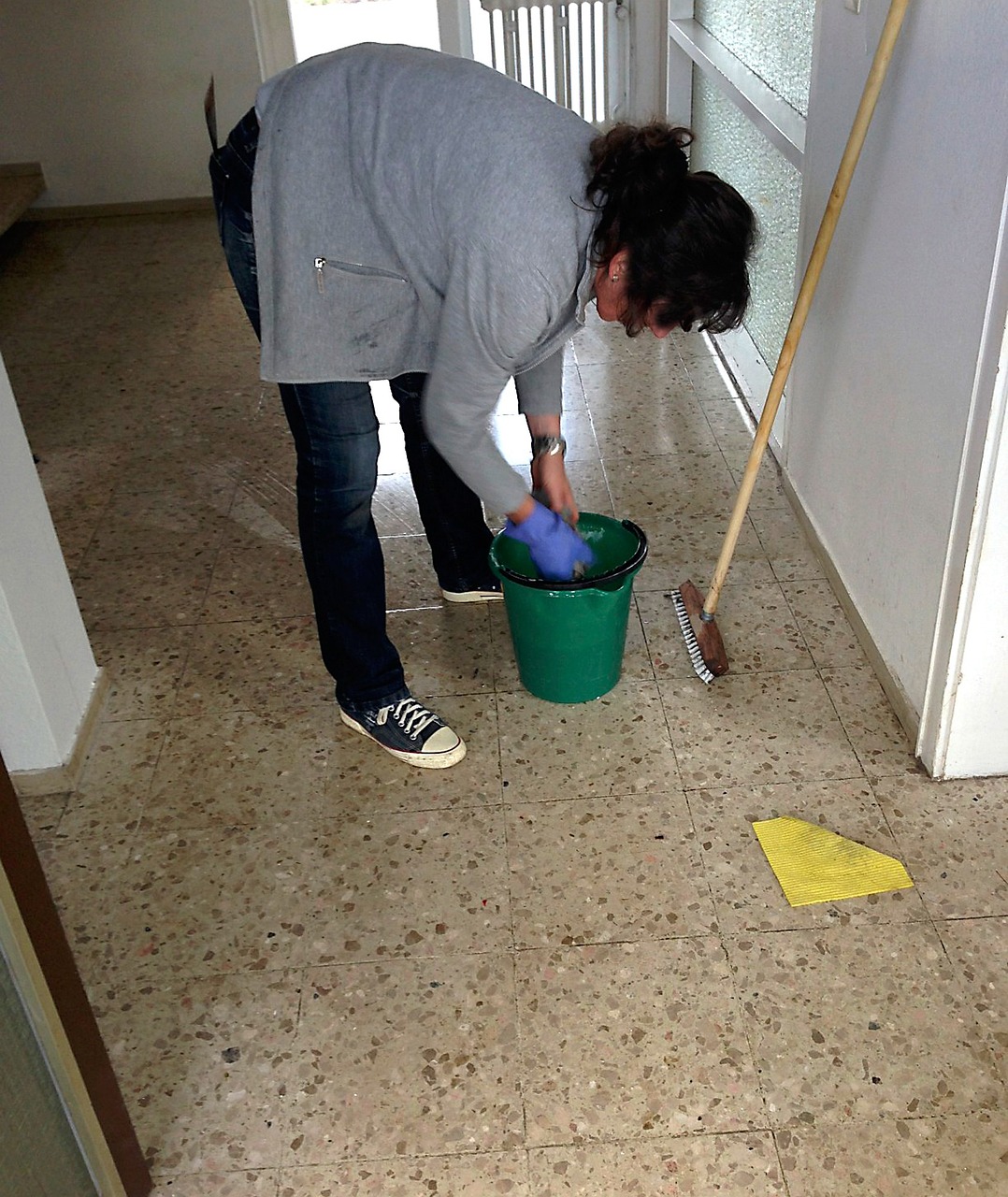 Whisk cleaner mopping the floor of a bright home kitchen