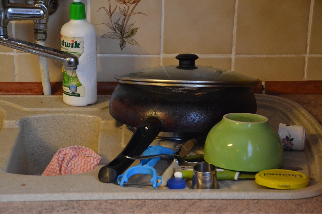 Kitchen before a Whisk clean: sink crowded with pans, bowls, and unwashed dishes